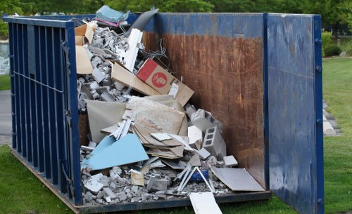 Team of waste removal operatives preparing equipment at a commercial site